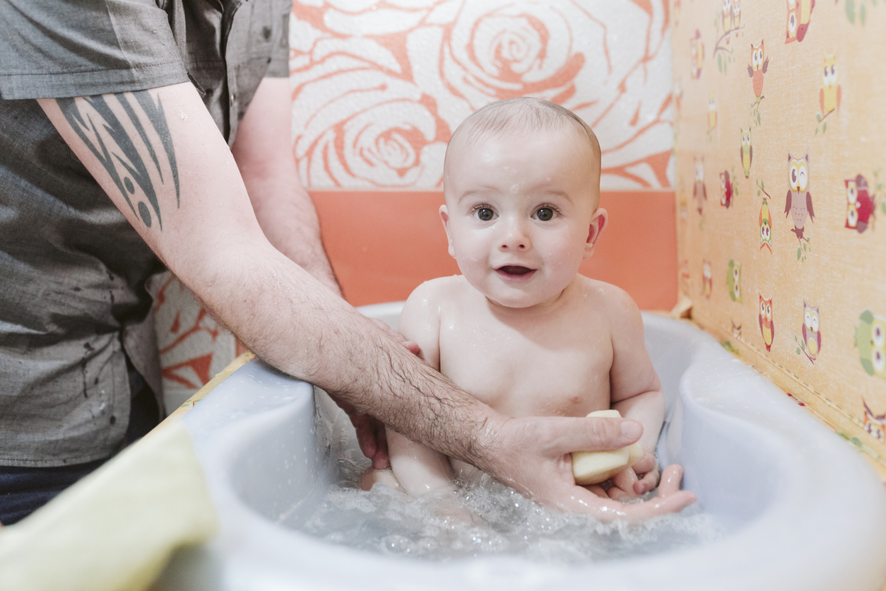 A baby being bathed, followed by reading a bedtime story.